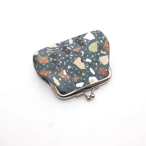 Detailed view of vintage kiss-lock coin purse with abstract stone pattern and silver metal clasp