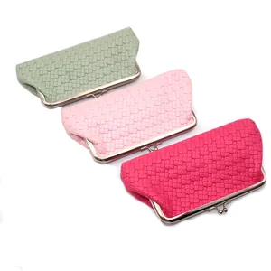 Detailweergave van geweven PU-lederen clutches in groen en roze met metalen sluitingen