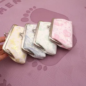 Dettaglio di quattro portamonete color pastello con stampa di farfalle e chiusura a scatto