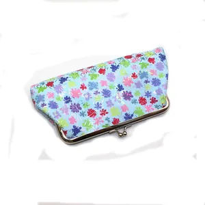 Dettaglio pochette in PU azzurro con stampa floreale e chiusura a clip in metallo oro