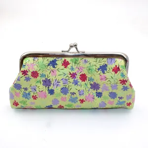 Dettaglio della pochette in pelle PU con stampa floreale laser e chiusura in metallo