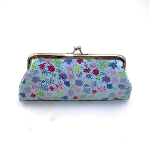 Dettaglio di borsa in pelle PU azzurra con stampa floreale e chiusura a scatto in metallo