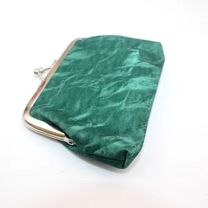 Detailopname van een vintage groene fluwelen PU-leren portemonnee met sluiting.
