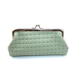 Detail van mintgroene geweven lederen clutch met vintage gouden kiss-lock metalen frame