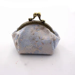 Detail van vintage blauwe brokaat portemonnee met gelukskat patroon en bronzen sluiting