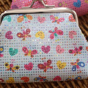 Macro shot of mini coin purse with holographic glitter and colorful butterfly pattern