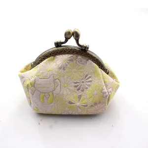 Detail van gele handgemaakte portemonnee met gelukskat en vintage metalen sluiting
