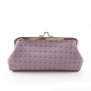 Detail van de geweven PU-lederen textuur en gouden sluiting op de lavendel clutch tas