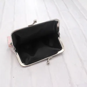 Detail view showing black fabric lining and kiss-lock closure of a 4-inch pink glitter coin purse