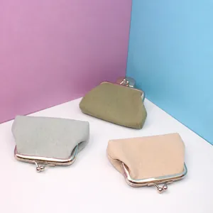 Three minimalist canvas coin purses with retro metal clasps in neutral colors