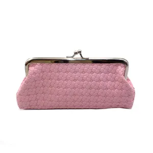 Detail van roze geweven PU-clutch met zilveren metalen kus-sluiting en verfijnde textuur
