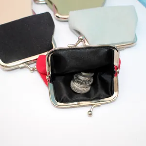 Detailed view of canvas coin purse with metal kiss-lock closure and interior coin storage