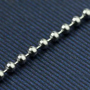 Macro detail of a silver-tone metal ball chain necklace showing polished bead texture