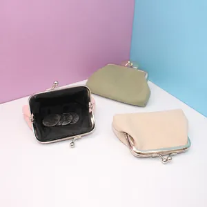 Detailed view of three vintage canvas coin purses with metal clasps in pastel colors