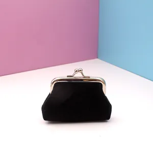 Detail of a soft black velvet coin purse featuring a silver metal kiss-lock clasp