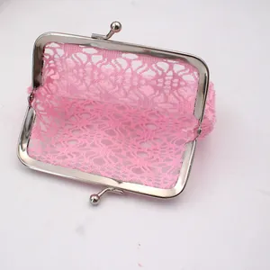 Detail van roze kant portemonnee met zilveren kiss-lock sluiting en mesh textuur