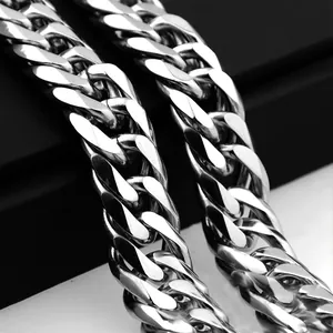 Detailed close-up of a chunky silver stainless steel Cuban link chain on leather background