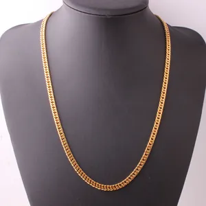 Detailed view of a gold Cuban link chain necklace on a black velvet display stand