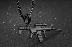 Macro shot of detailed black stainless steel rifle pendant on a checkered chain link