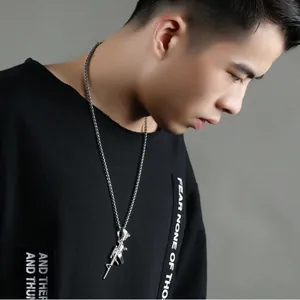 Detailed close-up of a silver stainless steel rifle pendant necklace on a male model