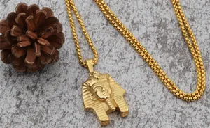 Macro shot of Egyptian Pharaoh Tutankhamun pendant on gold box chain with stone background