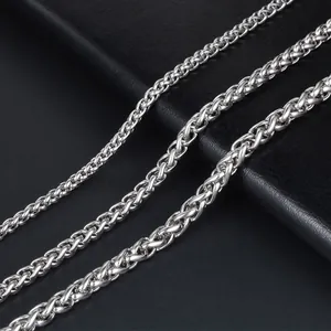 Macro detail of silver wheat chain necklaces in three different sizes on black leather