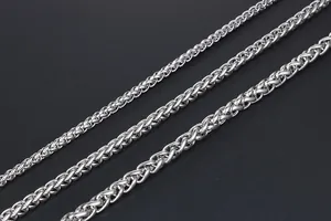 Detailed view of silver wheat spiga chain necklaces in three different thickness levels