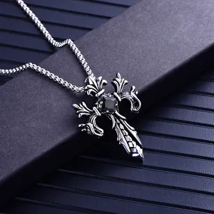 Macro detail of gothic cross necklace with double dragon motif and black square gemstone
