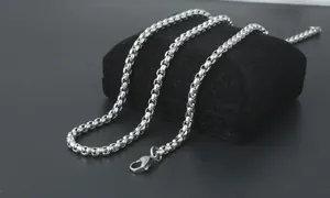 Macro shot of polished stainless steel box chain necklace with a secure lobster clasp