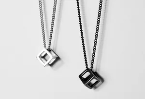 Detail view of hollow cube necklaces in polished silver and matte black titanium steel finish