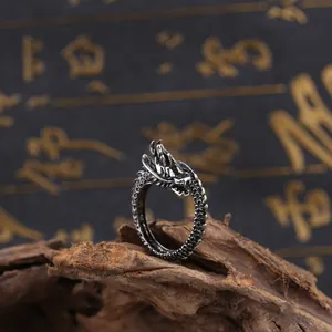 Makroaufnahme eines Vintage Drachenrings im Punk-Stil mit Details auf rustikalem Holz
