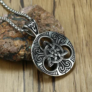 Retro stainless steel necklace with Celtic knot pendant on textured stone background