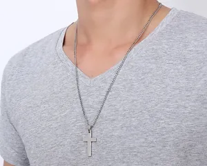 Close-up of a men's polished stainless steel cross pendant on a classic curb chain