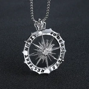 Macro shot of silver sun pendant with engraved motivational words on textured background