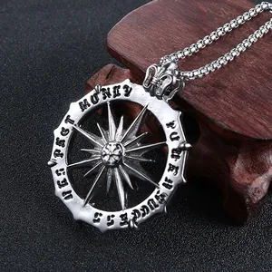 Detailed shot of silver compass pendant with Money Power Success Respect engravings