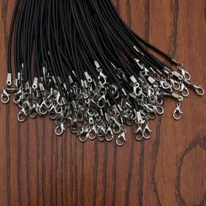 Multiple black wax cord necklaces with silver lobster clasps on a brown wooden surface