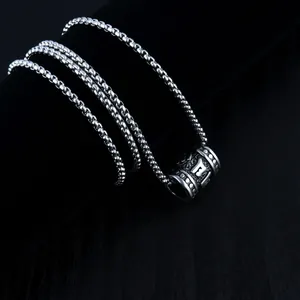 Silver stainless steel cylinder necklace featuring engraved Buddhist scripture motifs