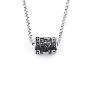 Macro detail of cylinder pendant with Buddhist mantra and oxidized silver finish
