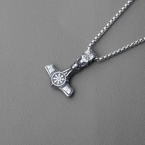 Detailed macro view of vintage stainless steel Mjölnir pendant with Thor's hammer engravings