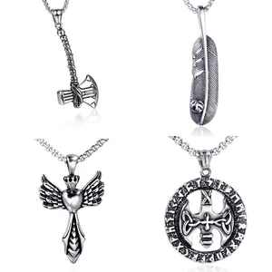 Macro detail of retro stainless steel pendants featuring axe, feather, and wing heart