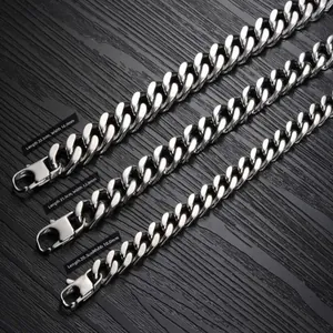 Three sizes of silver steel Cuban link bracelets with lobster clasps on dark wood