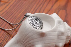 Detail of vintage stainless steel Eye of Horus pendant with hieroglyphics on a ball chain