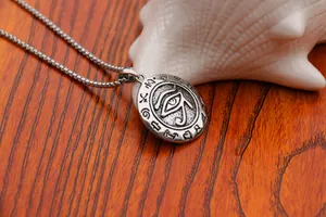 Detailed close-up of Eye of Horus pendant on a box chain over a rustic wooden surface