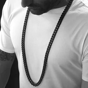 Close-up van dikke zwarte Cuban link ketting gedragen door mannelijk model op wit shirt