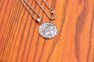 Detail shot of Eye of Horus pendant on a box chain with ancient Egyptian engravings