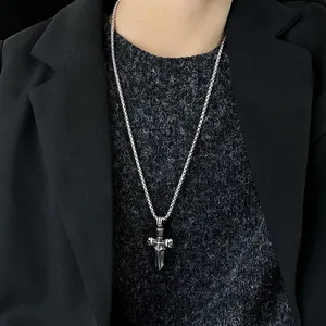Vintage stainless steel cross dagger pendant necklace on a silver chain worn by a model
