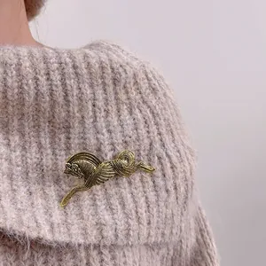 Vintage golden galloping horse brooch with textured metal on a knitted sweater