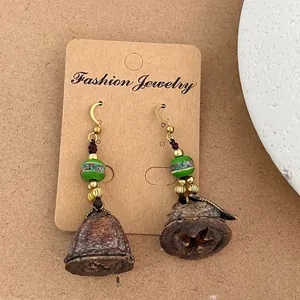 Détail de boucle d'oreille vintage faite main avec cosses séchées et perles colorées