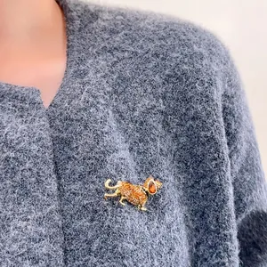 Broche teckel exquise avec cristaux bruns sur un pull gris, accessoire de mode chic