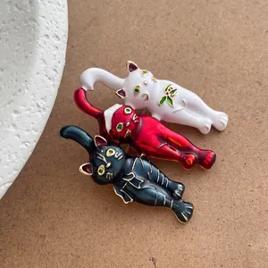 Vintage Christmas cat brooch set with red white and black enamel on a wood base